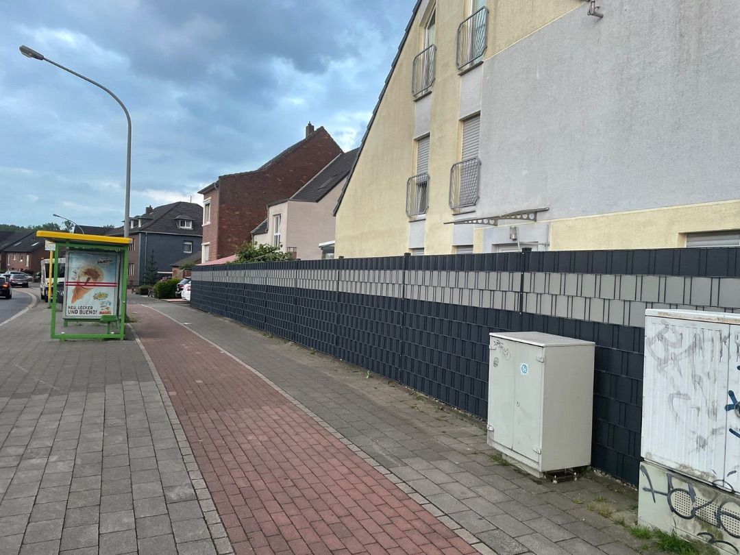 Sichtschutzzaun, der als Aufsatz auf einer bestehenden Natursteinmauer montiert wurde